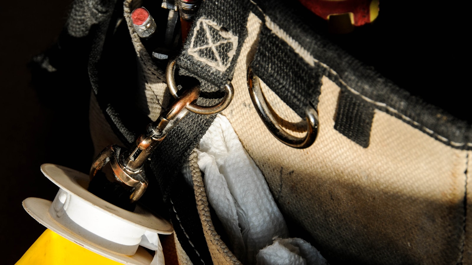 Plumbing tool bag with thread-seal tape — unnamed stock, not a named crew portrait.